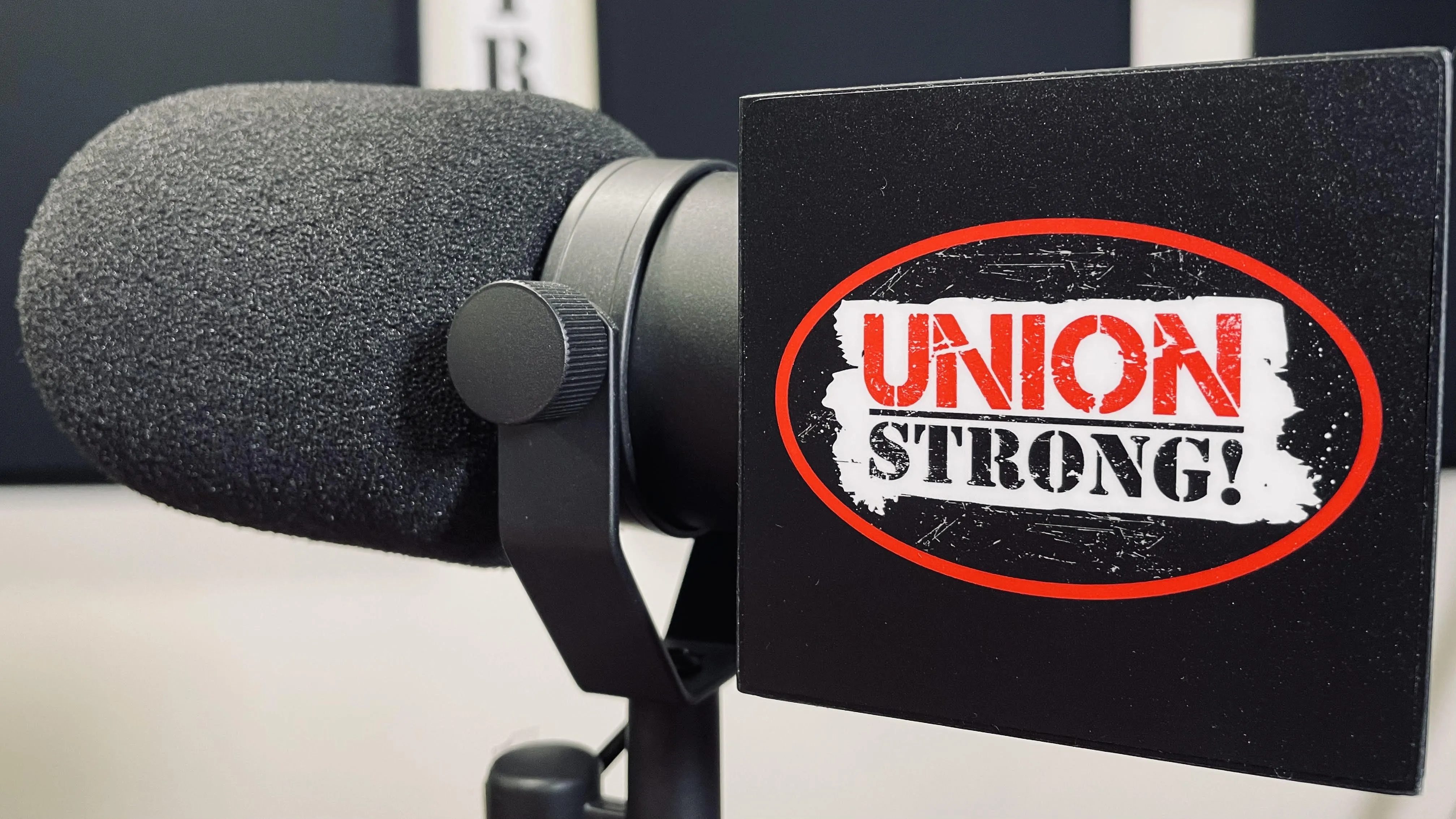Microphone in podcast studio with NYS AFL-CIO Union Strong logo